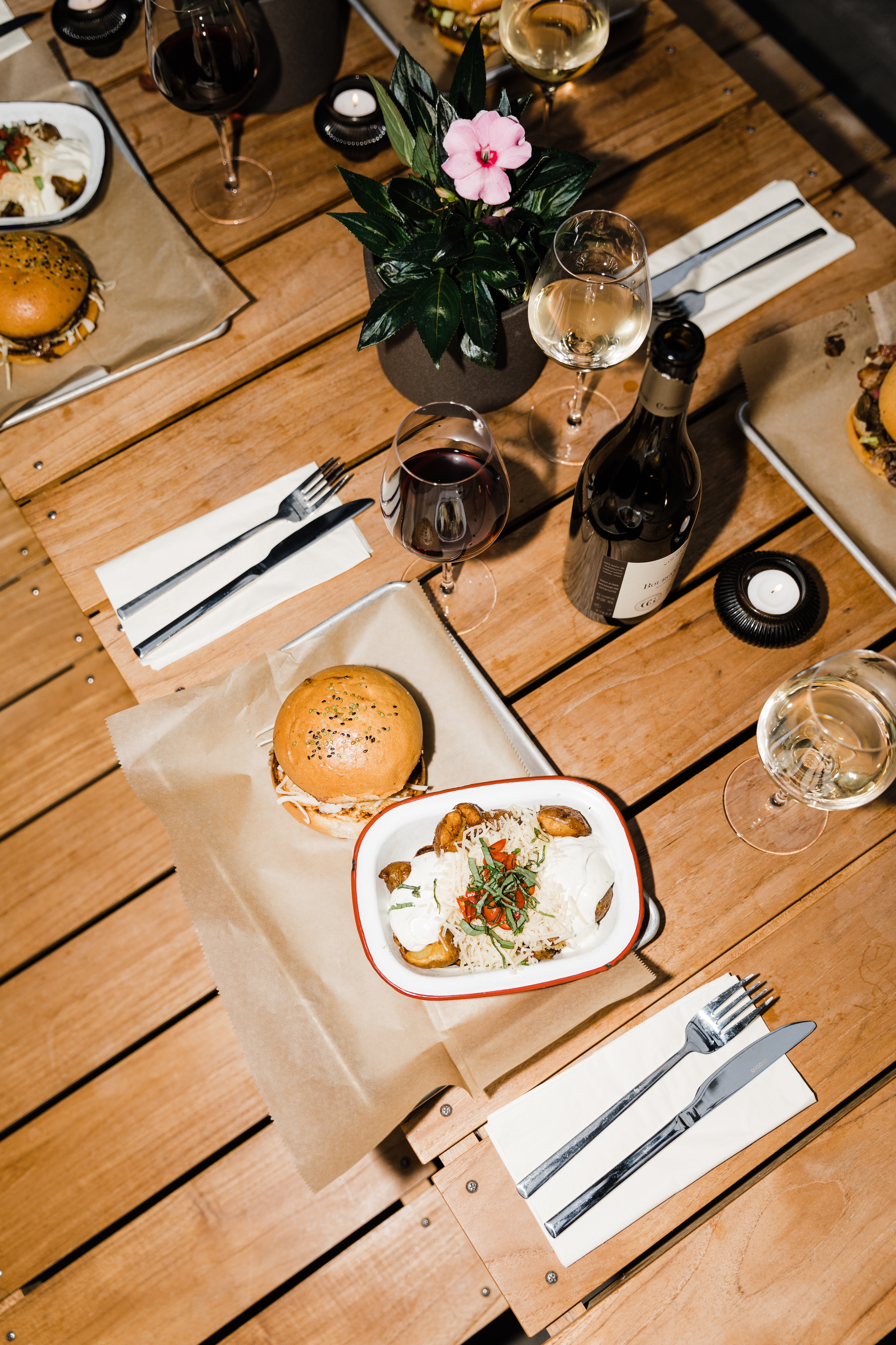 Hotel Exeter - burger and food on a wooden table in a white bowl