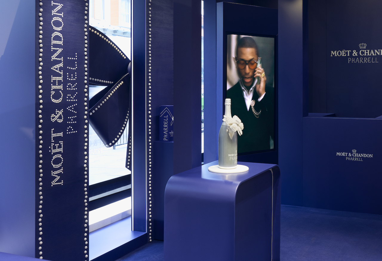 Pharrell Moët & Chandon Harrods Pop-Up - the royal blue interiors of the pop-up gift shop withthe Pharrell campiagn playing on a screen and The Jewel Masterpiece in a glass case