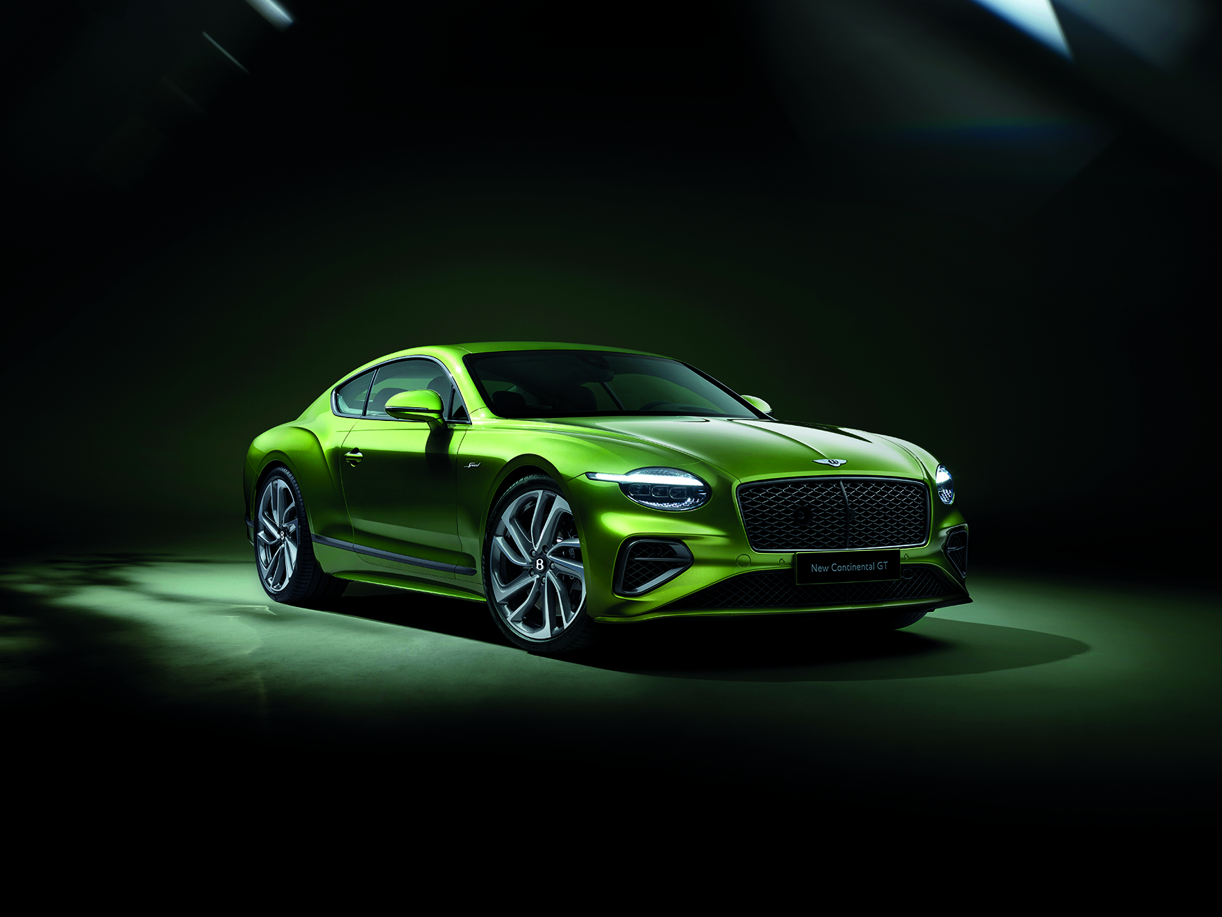 The heritage car Bentley Continental GT, in a green shade underneath a green spotlight.