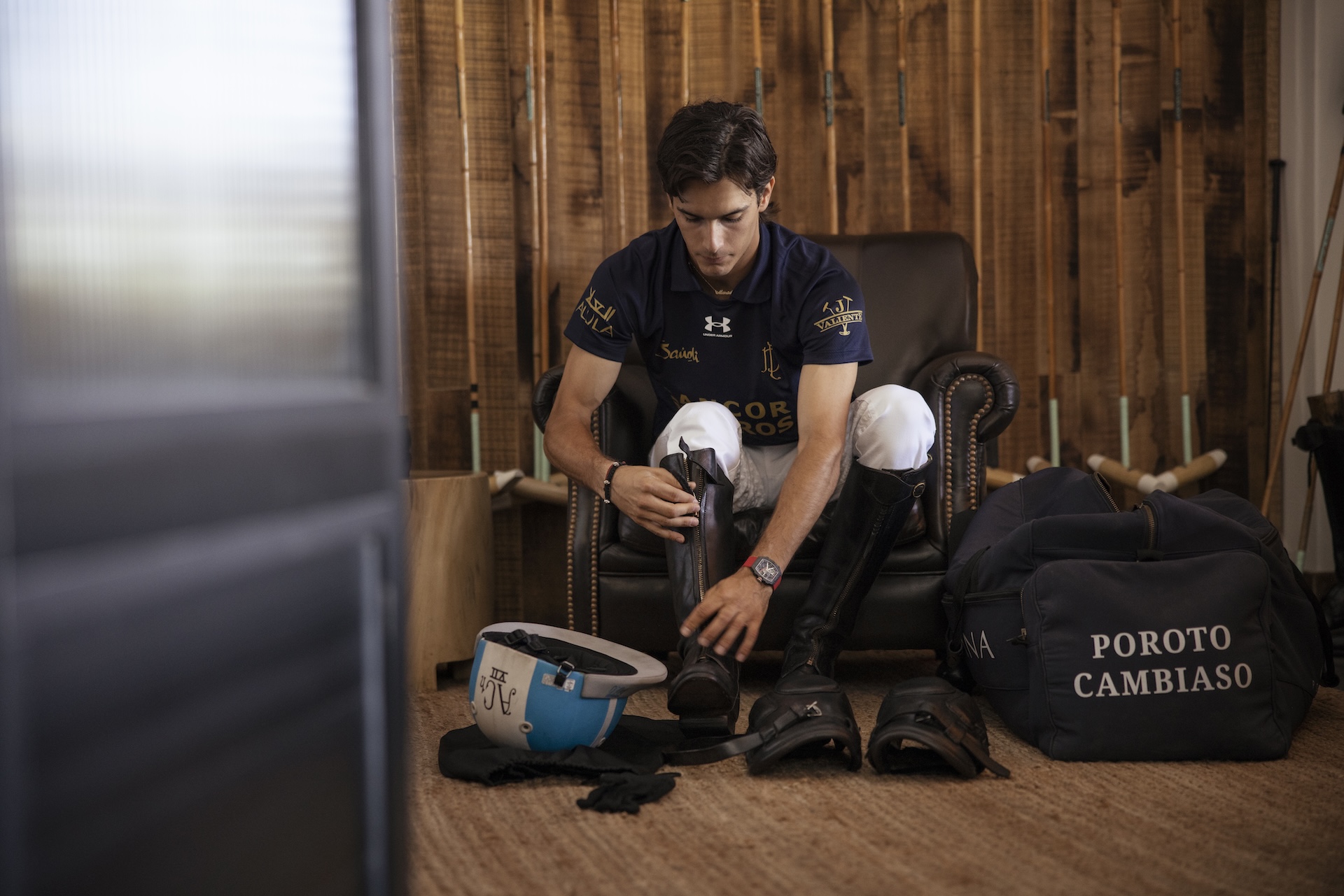 Poroto Cambiaso zipping up his riding boots. 