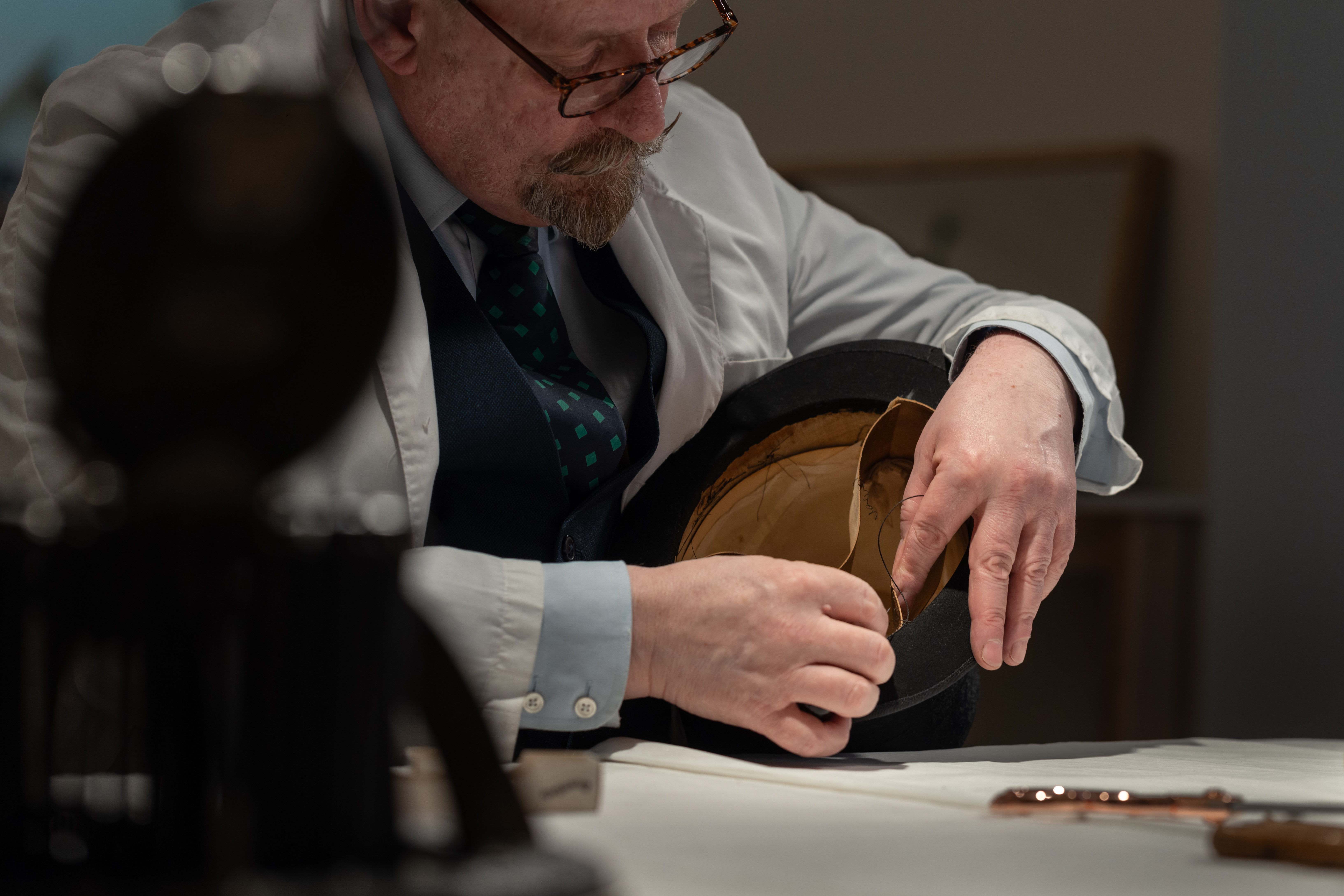 Craftsman working on a Swaine product by hand.
