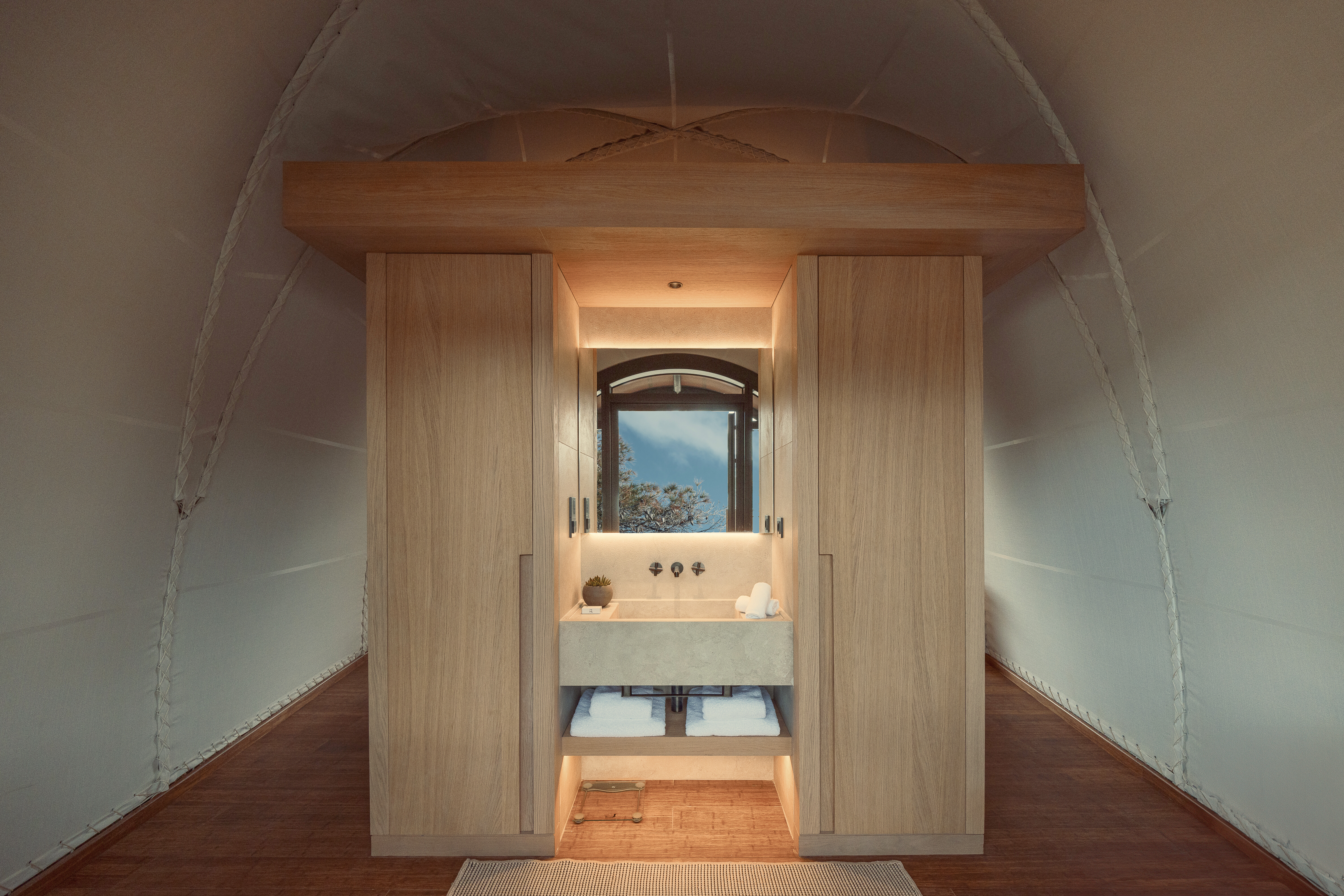 Behind the grand sleeping station, shelves hold luxury essentials provided by Domes Resort Athens