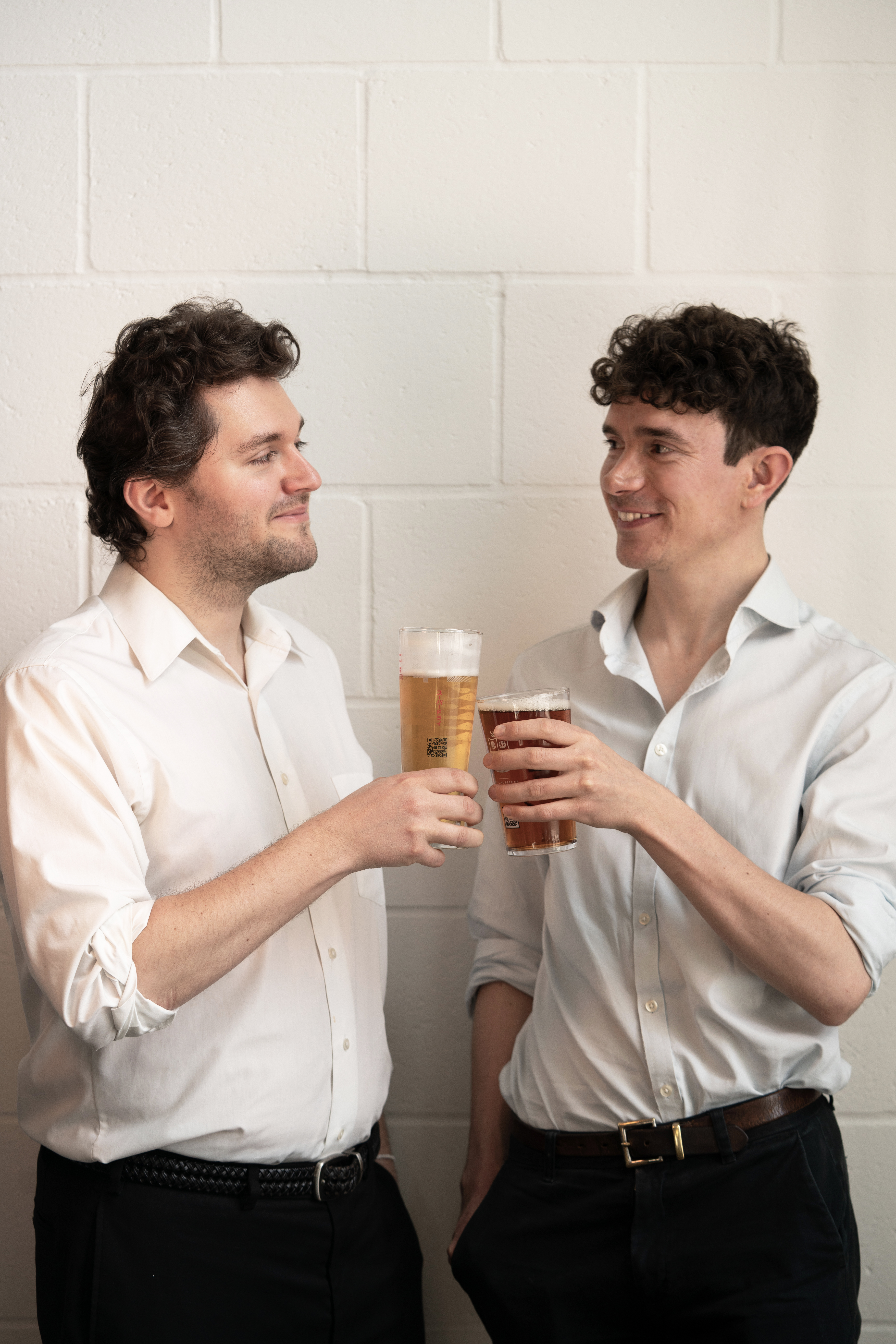Arda founders Brett and TJ holding beers, its waste material makes their bio-textiles