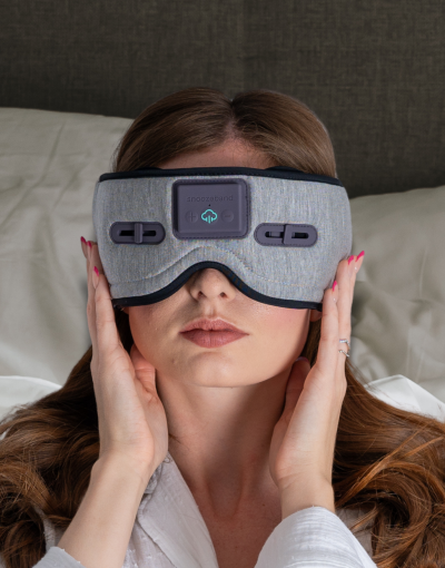 Effective Products Deeper Sleep - a woman lying down on white pillows with a grey sleep mask on